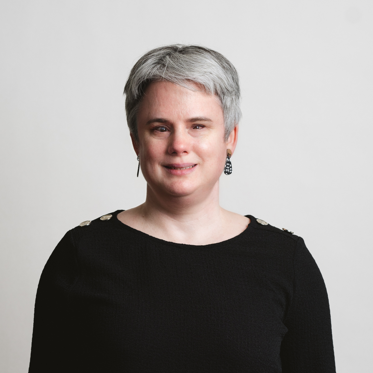 Lauren Hayes, a woman with short silver hair, smiling, wearing a black top